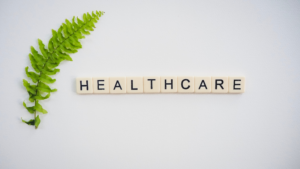 「HEALTHCARE」の文字ブロックと観葉植物（化学物質管理のイメージ）